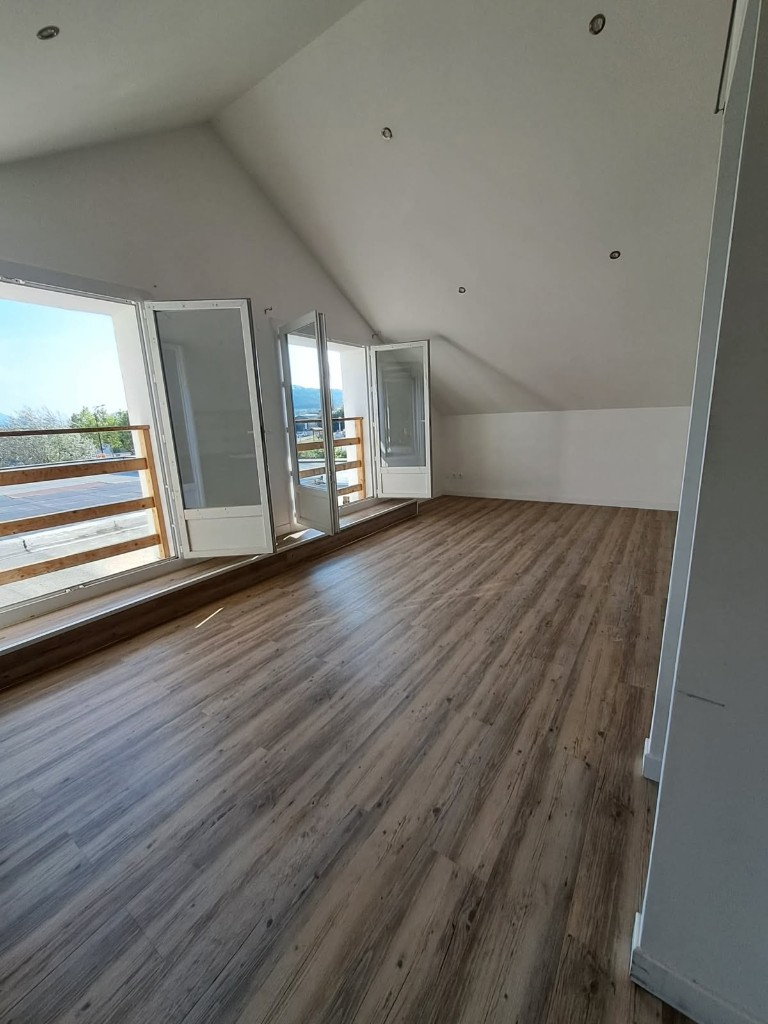 Combles aménagés avec parquet bois et portes-fenêtres